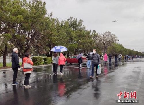 美国旧金山湾区民众在位于福斯特城的Costco超市外冒雨排起长队，等候购买物资。<a target='_blank' href='http://www.chinanews.com/'>中新社</a>记者 刘关关 摄