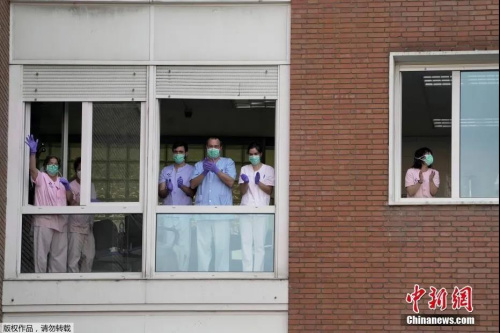 当地时间4月15日，西班牙巴塞罗那，在新冠肺炎疫情期间，健康工作者在阳台和窗户前向市民表示支持。