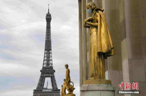 　资料图：当地时间5月8日“欧洲胜利日”拍摄的雕塑，背景为埃菲尔铁塔。法国将于5月11日起逐步“解封”，为了提醒民众“解封”后注意防护，巴黎著名景点夏洛宫外的金色雕塑被戴上了口罩。<a target='_blank' href='http://www.chinanews.com/'>中新社</a>记者 李洋 摄
