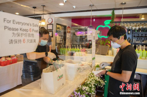 当地时间5月9日，美国硅谷腹地库比蒂诺商圈的“青苹果”餐厅在一条长桌上立起透明的挡板，店员与取餐者隔着挡板交流。 <a target='_blank' href='http://www.chinanews.com/'>中新社</a>记者 刘关关 摄