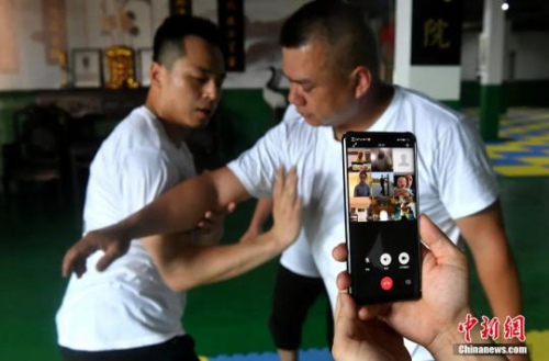 　余丹秋与徒弟们通过微信群视频为澳大利亚鸣鹤拳爱好者传授鸣鹤拳入门套路“八步连”。吕明 摄