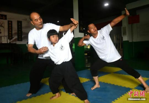 余丹秋指导9岁的郑施泽学习鸣鹤拳。吕明摄