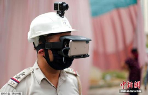 　资料图：当地时间5月11日，印度新德里街头，为防止新冠肺炎疫情的扩散，警察带着一款特制头盔上岗，头盔顶端设有监控器，面部用除佩戴口罩外，还有一款链接手机的智能眼罩。