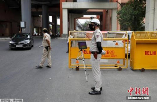 　当地时间5月11日，印度新德里街头，为防止新冠肺炎疫情的扩散，警察带着一款特制头盔上岗，头盔顶端设有监控器。