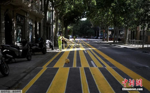 资料图：西班牙巴塞罗那街道上，工人们扩展人行道面积，以便利行人保持社交距离。