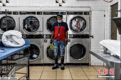 　全球疫情之下，各行各业中还有很多人为了保障人民的日常生活，在自己的工作岗位上坚持着。图为美国一家洗衣店里的员工。