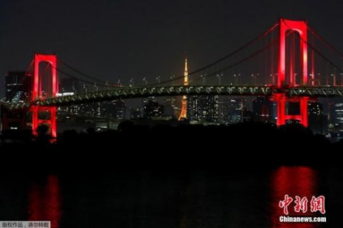 当地时间6月2日，日本东京地标性建筑彩虹桥亮起红灯。