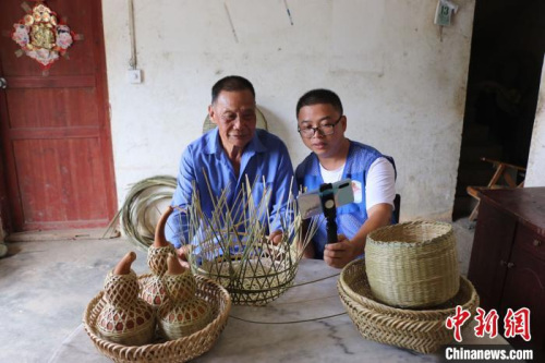梁福年通过网络直播方式帮助苏国厚销售竹编助增收。 钟鸣 摄 梁福年通过网络直播方式帮助苏国厚销售竹编助增收。 钟鸣 摄