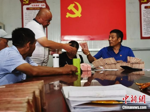 菏泽定陶区南城社区居民马利拿到了承包3个黑皮鸡枞菌大棚这一季的11万元分红。杨飞 摄 菏泽定陶区南城社区居民马利拿到了承包3个黑皮鸡枞菌大棚这一季的11万元分红。杨飞 摄