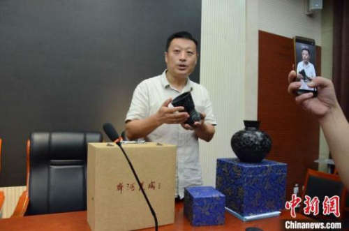 齐河黑陶技艺非遗项目传承人、2019年“山东非遗+旅游文创大赛”获奖代表刘旋子介绍他的获奖作品。 孙婷婷 摄 齐河黑陶技艺非遗项目传承人、2019年“山东非遗+旅游文创大赛”获奖代表刘旋子介绍他的获奖作品。 孙婷婷 摄