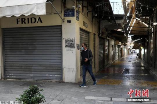当地时间11月7日，希腊雅典，行人经过关闭的商业街。为遏制新冠疫情，自当地时间7日早晨6时起，希腊全国进入为期三周的封锁状态。包括零售店、餐厅、咖啡馆等企业，将在封锁期间暂停营业。