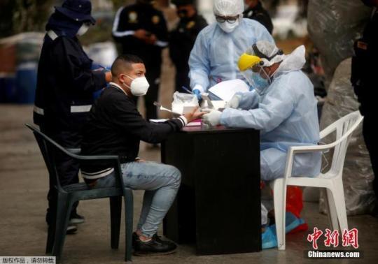 资料图：当地时间2020年8月22日晚，秘鲁警方对一家违反防疫规定经营的夜店采取取缔行动。图为被拘者在进行核酸检测。
