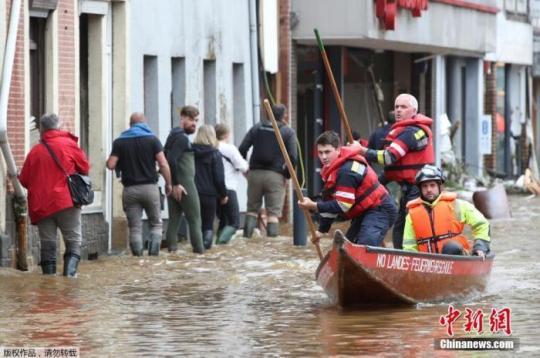 当地时间7月16日，比利时Pepinster，救援队队员撑船穿过受洪水侵袭的地区。