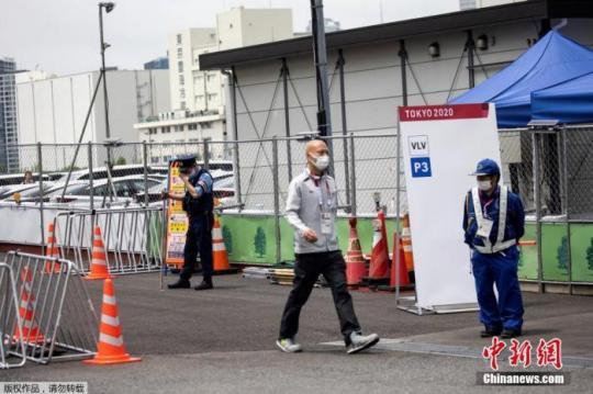 图为东京2020年奥运会的一名参赛者通过安保人员走出东京奥运村和残奥会村。
