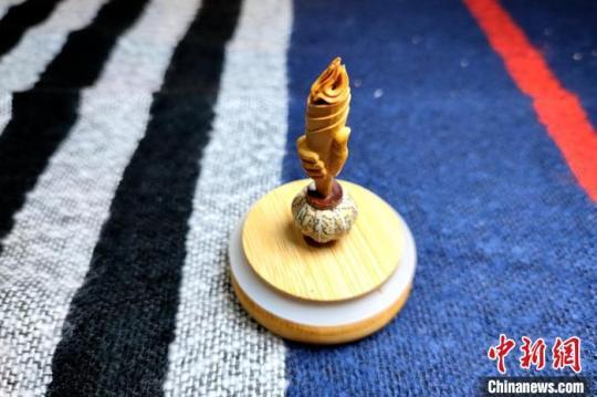圖為黃樹立創(chuàng)作的核雕“火炬”?！∶疯O瀧 攝
