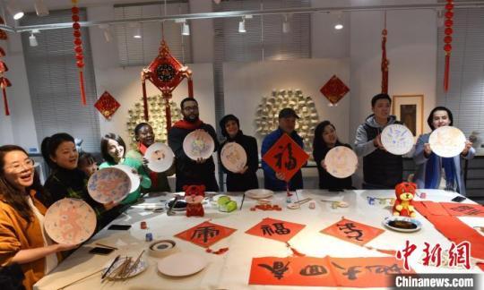 景德镇陶瓷大学国际学院院长张婧婧(右三)和该校留学生一起展示创作的“虎”主题陶瓷作品。　程万海 摄