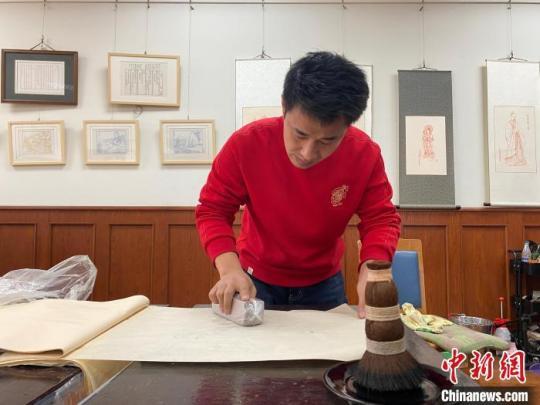 李振豪進(jìn)行虎年年畫印刷的步驟?！±蠲鬈?攝