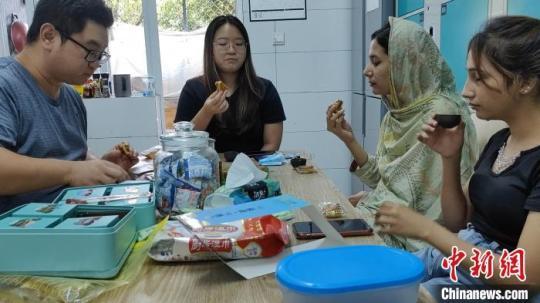 谢志功和外籍学生品尝月饼、喝茶聊天。　受访者供图