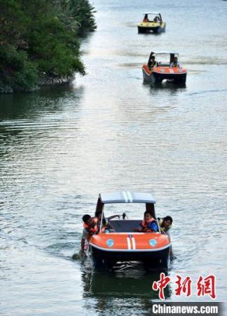 图为10月2日，游客驾驶着游船在福州流花溪上巡游。　张斌 摄