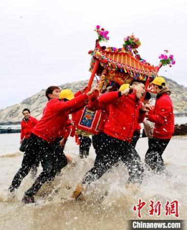 信众抬着神轿冲海祈福。　陈斌 摄