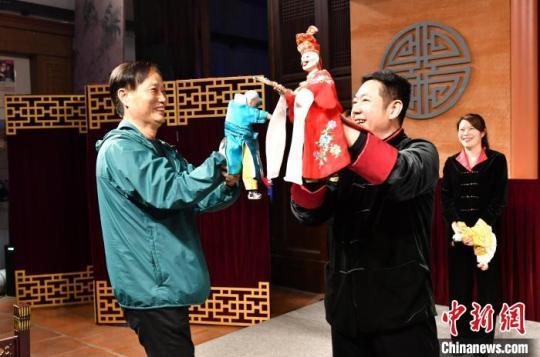 华文媒体代表欧阳乐耕(左)体验木偶操作并与木偶表演艺术家陈黎晖互动。　吕明 摄