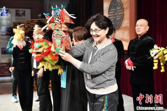 华文媒体代表陈薇(前)体验布袋木偶操作。　吕明 摄