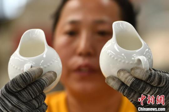 5月18日，山西省朔州市应县，博达瓷业有限公司工人在车间赶制手工茶壶订单，进行拣选作业。　韦亮 摄
