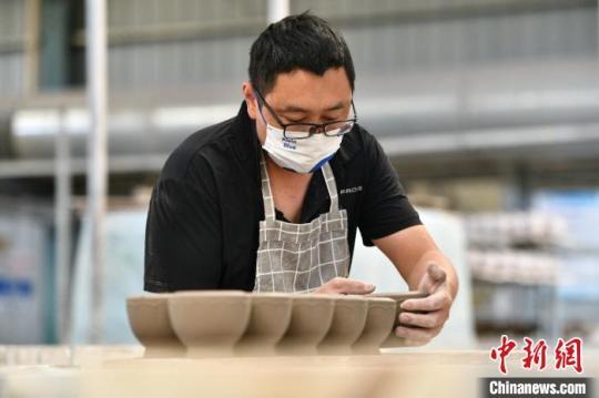 5月18日，山西省朔州市应县，博达瓷业有限公司工人在车间赶制手工茶壶订单。　韦亮 摄