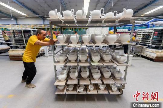 5月18日，山西省朔州市应县，博达瓷业有限公司工人在车间赶制手工茶壶订单，准备上炉烧制坯体。　韦亮 摄