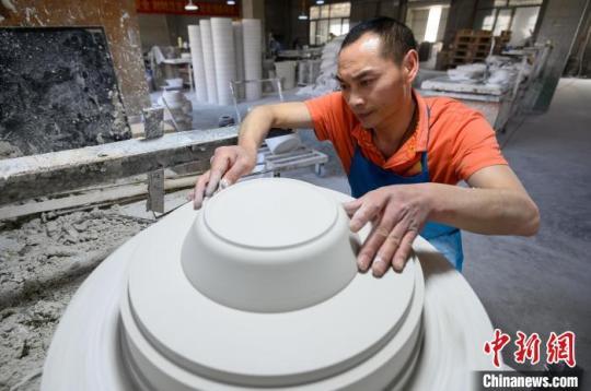 5月18日，山西省朔州市应县，博达瓷业有限公司工人在车间赶制手工茶壶订单，生产石膏模具。　韦亮 摄