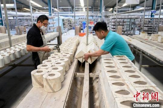 5月18日，山西省朔州市应县，博达瓷业有限公司工人在车间赶制手工茶壶订单，进行注浆作业。　韦亮 摄