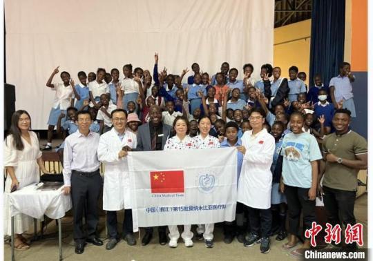 医疗队与当地民众合影留念。　浙江省中山医院供图