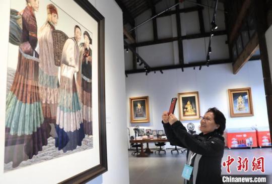 一位海外华媒代表在一家博物馆拍摄展出的蜀绣作品。　王磊 摄