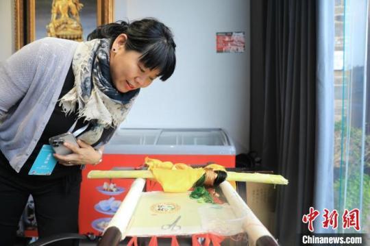 一位海外华媒代表在一家博物馆观看尚未完成的蜀绣作品。　王磊 摄
