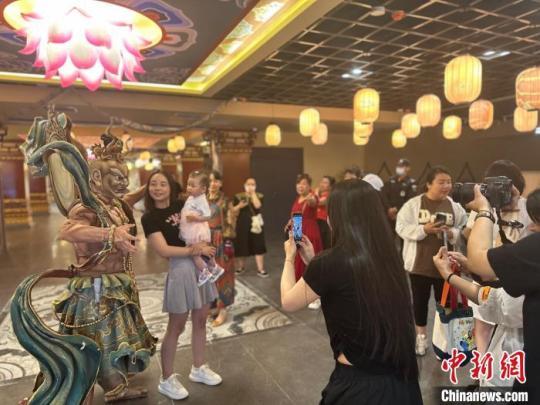 上元市集围绕“剧”“艺”“食”“趣”四大亮点，打造了文旅综合体。图为敦煌壁画中金刚形象吸引民众合影。　闫姣 摄
