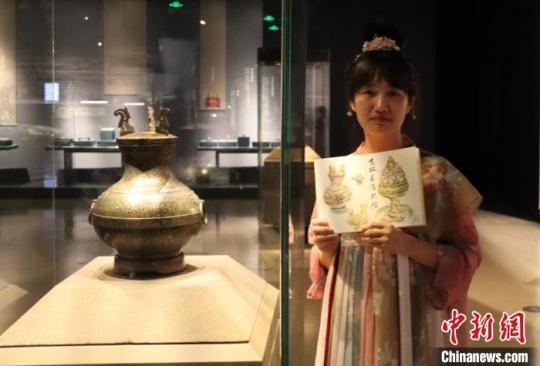 汉服爱好者在展示她绘制的错金银鸟篆文铜壶。　张瑶 摄
