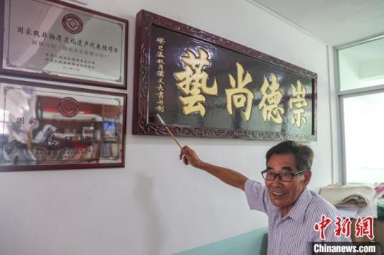 图为赣南客家匾额习俗的传承人肖天长在介绍客家匾额的历史。　刘力鑫 摄