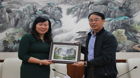 湖南省外侨办副主任张建新与英国湖南同乡会会长吴莉莉交换礼物。