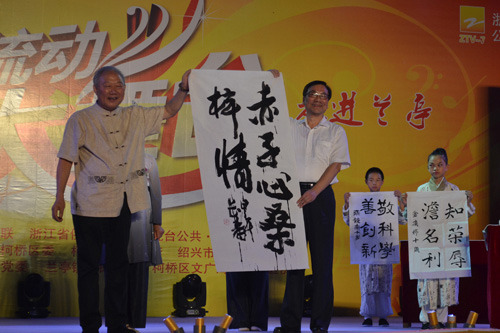 原绍兴市委副书记、绍兴市书法协会会长袁长寿（左）当场书写《赤子心桑梓情》赠与省侨联。
