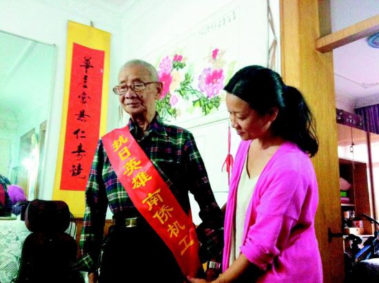 中国侨网女儿苏小红为老人整理绶带。（《太原晚报》/裴怡 摄）