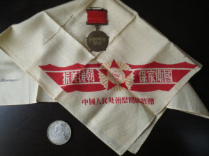 中国侨网周祝令珍藏60多年的3件纪念品:一枚抗美援朝纪念章、一方“抗美援朝、保家卫国”手帕和一块救命银元。(《青田侨报》)