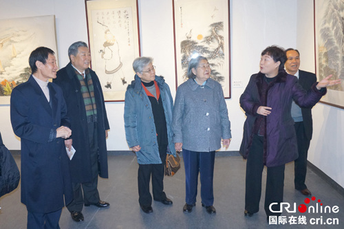 中国侨网著名华人画家区本陪同毛泽东女儿李敏参观画展。（国际在线）