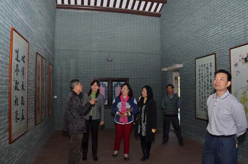 中国侨网广州市侨办副主任唐忆春参观南村村民书画室。