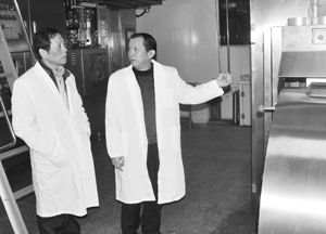 中国侨网图为关文良(左)参观乳业生产车间。