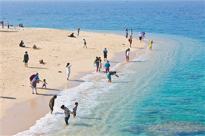 中国侨网游客在陵水分界洲岛沙滩享受大海。(李幸璜 摄)