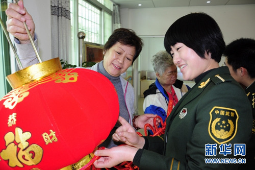 中国侨网官兵为侨胞送上红灯笼。(新华网)