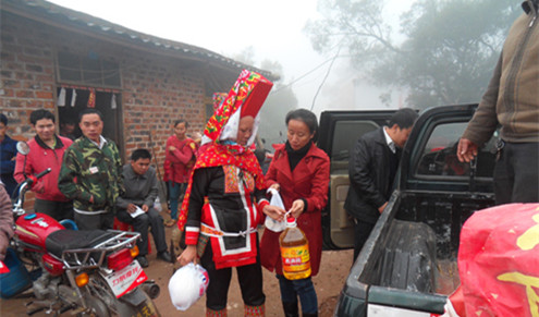 中国侨网宁明县外侨办工作组在给瑶族侨胞发慰问品。