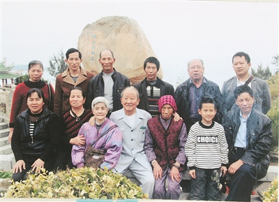 中国侨网陈兴顺(前排左四)与妻子(前排左三)和大姐何赛玉(前排右三)及侄儿侄女们在东山风动石景区合影。