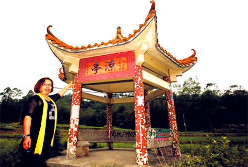 中国侨网余曼屏介绍白沙文化站为全镇280个自然村雕凿的亭碑字匾。(郑迅 摄)
