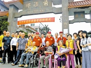 中国侨网吴仁平回到故乡与亲人和志愿者合影(前排中为吴仁平)。(《深圳特区报》/吴绪山 摄)